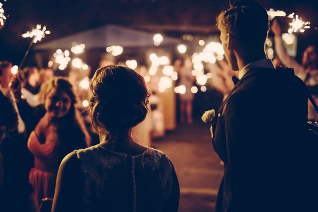 man and woman seeing a friend with fireworks in her hand