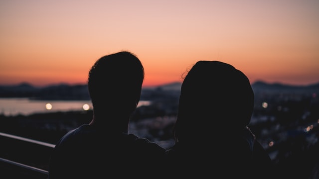 man and woman looking at the sunset