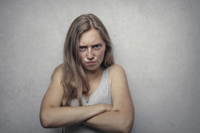 woman in gray tank top looking furious