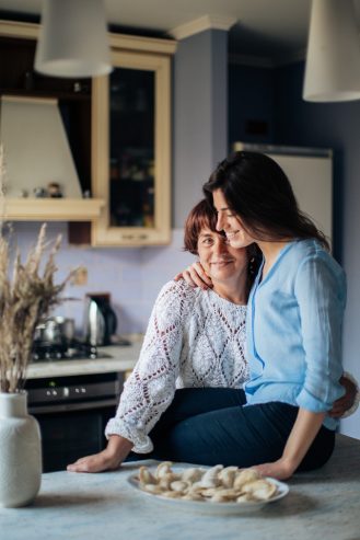 woman in white long sleeve shirt hugging her daughter