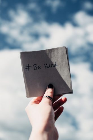 person holding a be kind note