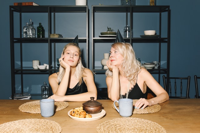 mom and daughter talking with hands on their chin