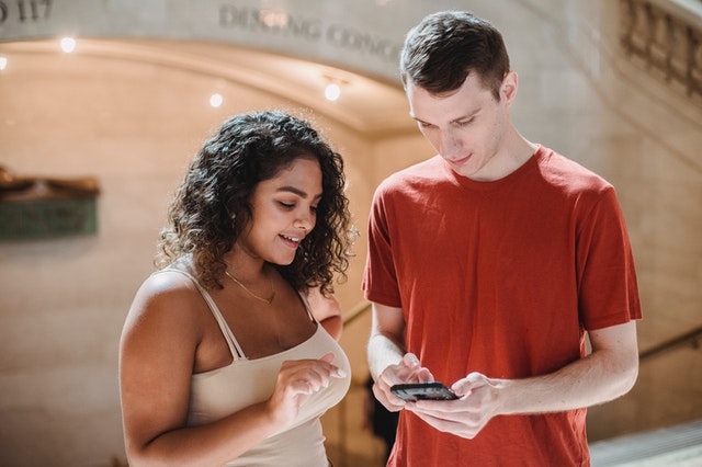 man showing his phone to a woman
