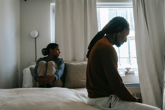 sad african american couple during quarrel on bed