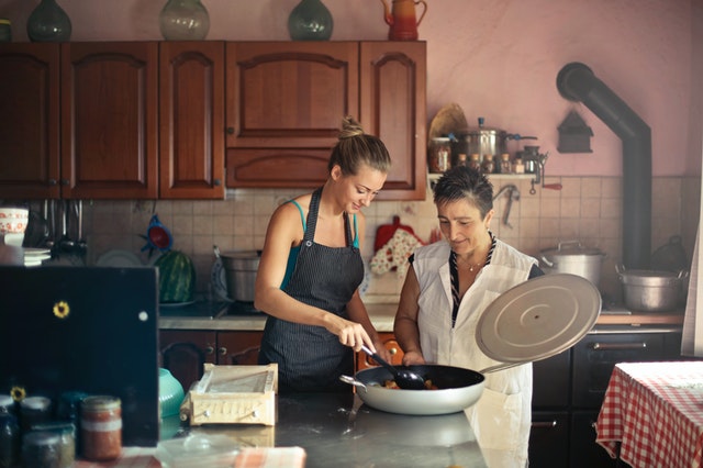 cheerful women cooking together in the kitchen
