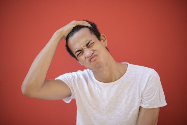 young displeased man with piercing making face