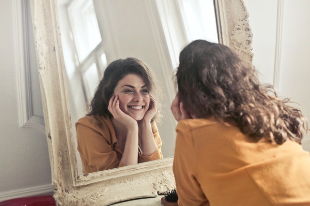 smiling woman looking at the mirror