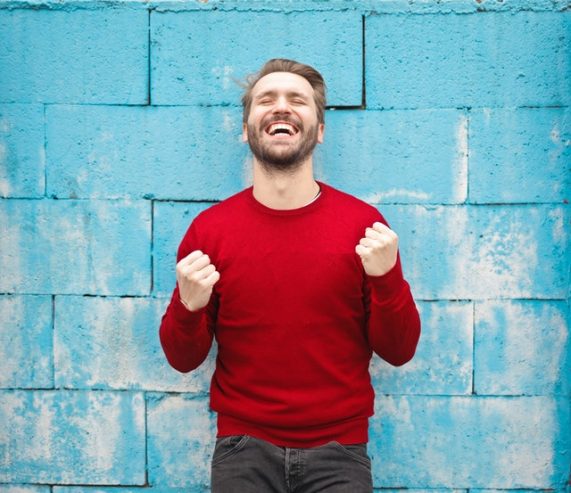 man in red crew neck sweatshirt smiling