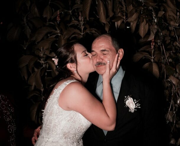 elegant bride kissing father on wedding day