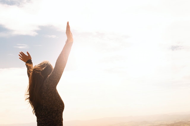 photo of a woman raising both hands