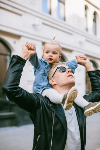 dad looking up at the sky while carrying his child