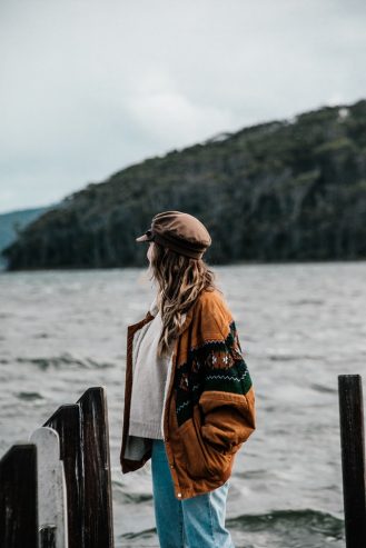 woman standing on pier admiring the lake