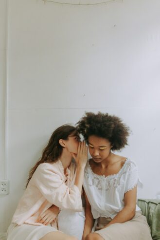 woman whispering to another woman